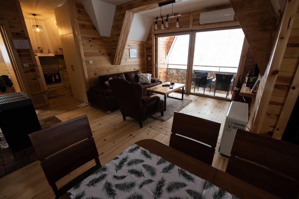 a living room with a couch and a table at Apartman Crni bor 2 Tara in Kaludjerske Bare