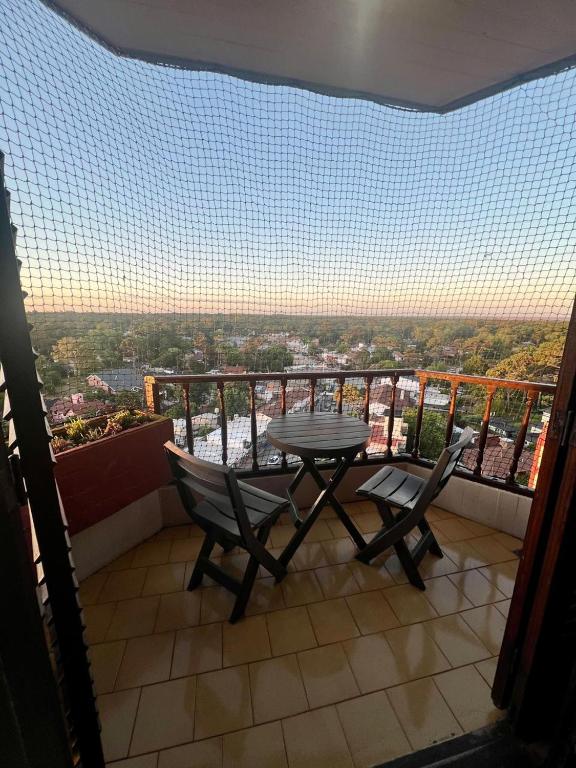 a table and chairs on a balcony with a view at Bosque y Mar - 11 C - TAXCO in Villa Gesell