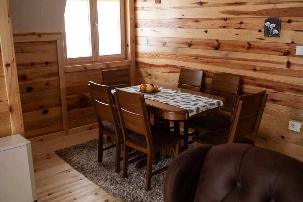 a dining room with a table and chairs in a cabin at Apartman Crni bor 2 Tara in Kaludjerske Bare