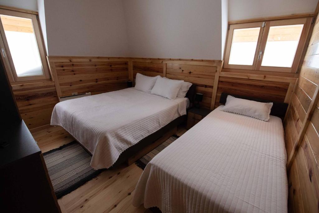 a room with two beds and two windows at Apartman Crni bor 2 Tara in Kaludjerske Bare