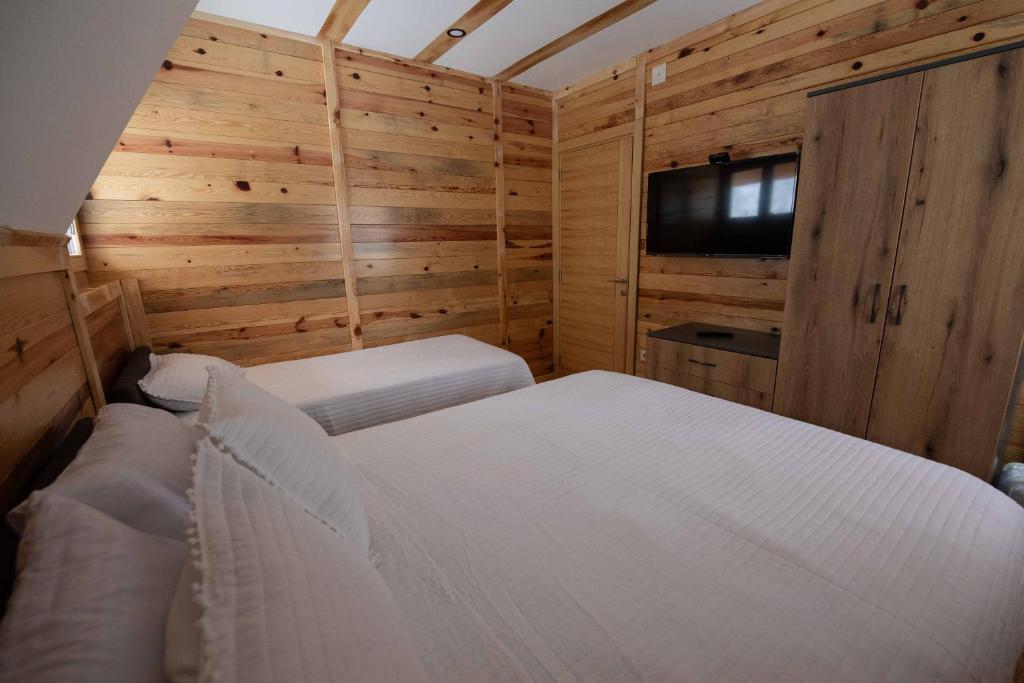 a bedroom with a bed and a flat screen tv at Apartman Crni bor 2 Tara in Kaludjerske Bare