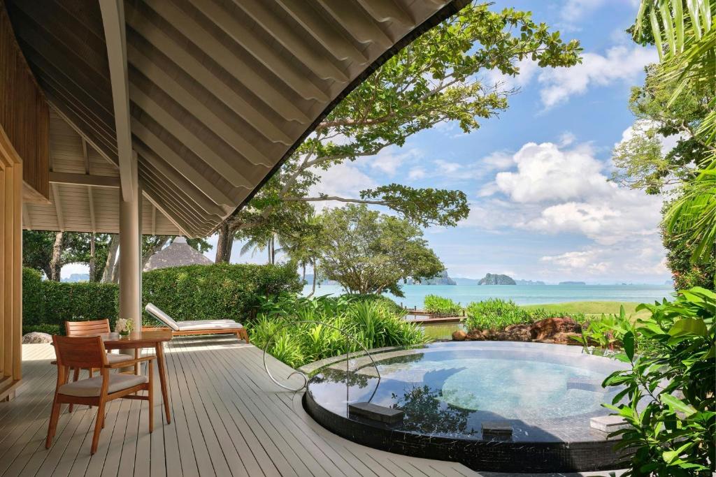 an outdoor patio with a hot tub and a table and chairs at Phulay Bay, A Ritz-Carlton Reserve in Tab Kaek Beach