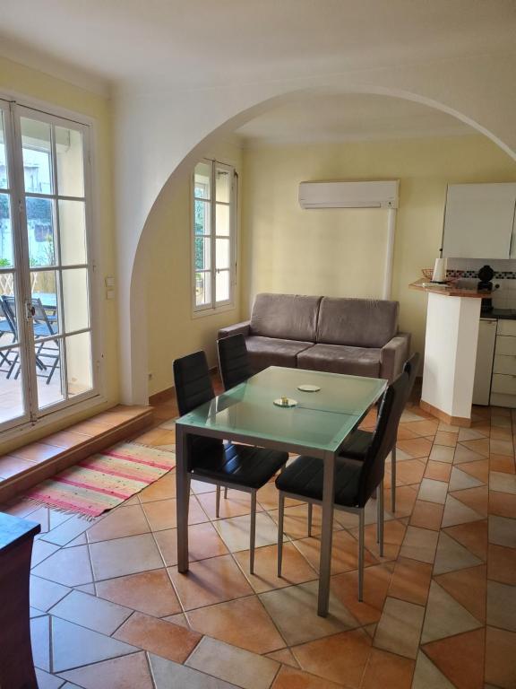 un salon avec un canapé, une table et des chaises dans l'établissement Le Pin Doré, à Antibes