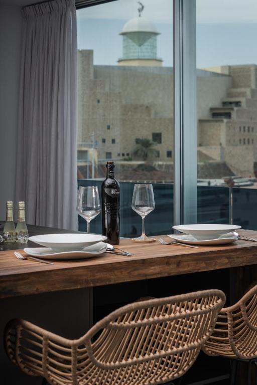 a wooden table with two glasses and a bottle of wine at Gold Suite Canteras by Canarias Homelidays in Las Palmas de Gran Canaria