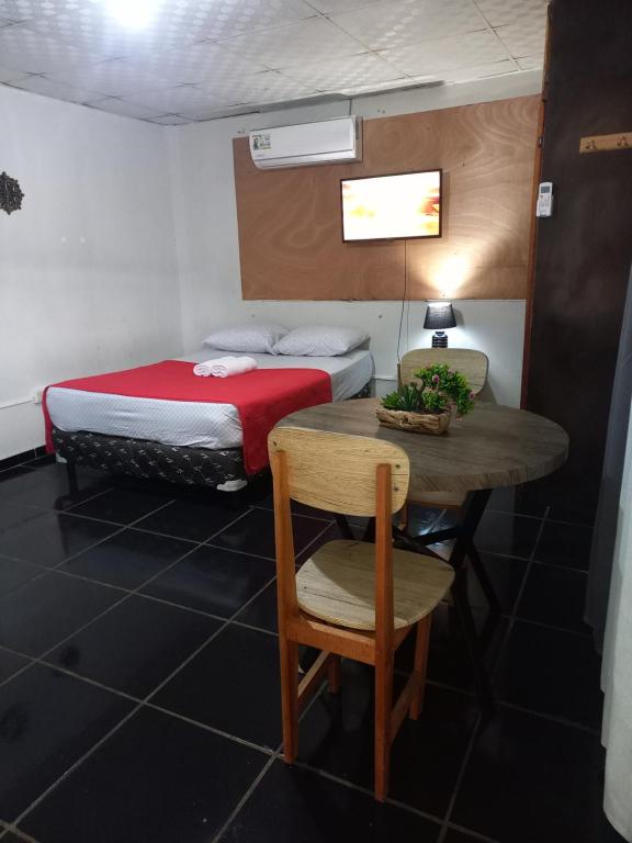 Habitación con cama, mesa y cama en Apartahotel los cactus, en David