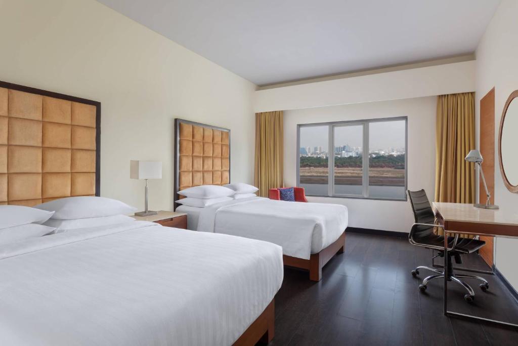 Postel nebo postele na pokoji v ubytování Surat Marriott Hotel