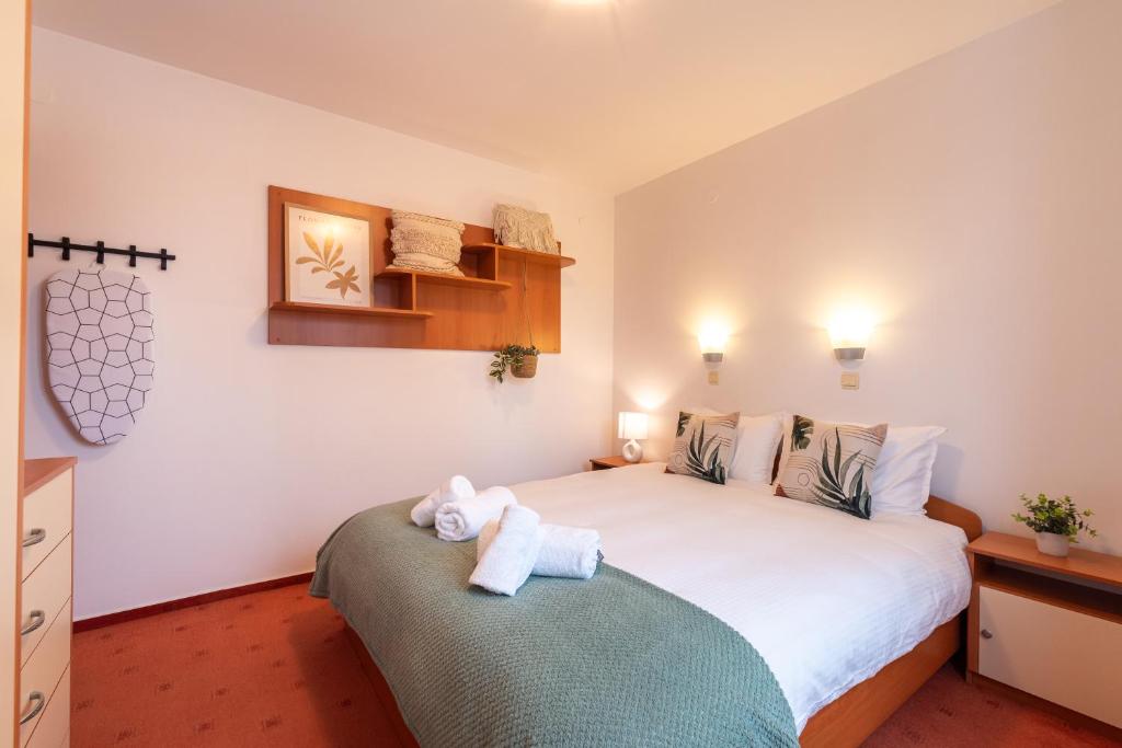 een slaapkamer met een groot bed met twee handdoeken erop bij Cozy Mountain View Apartment with Balcony & Ski Access nearby - Serendipity in Bansko