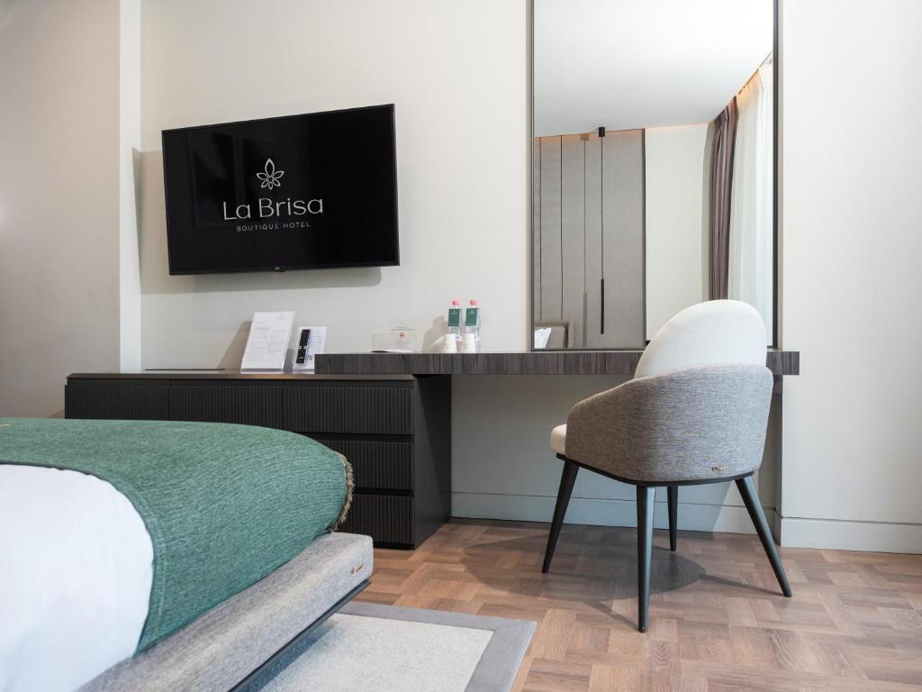 a bedroom with a bed and a desk and a chair at La Brisa Boutique Hotel in Dhërmi
