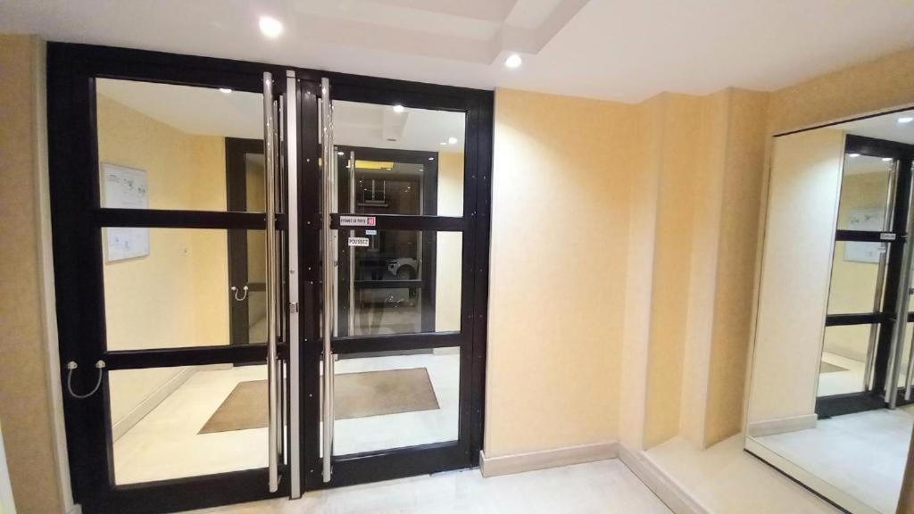 an empty room with a glass door in a building at Charmant appartement en plein centre ville de Nogent sur Marne in Nogent-sur-Marne