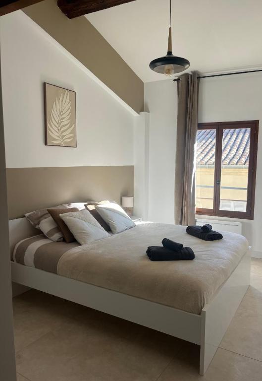 une chambre avec un grand lit avec deux serviettes dessus dans l'établissement MH Logement - Escapade aux Arènes, à Nîmes