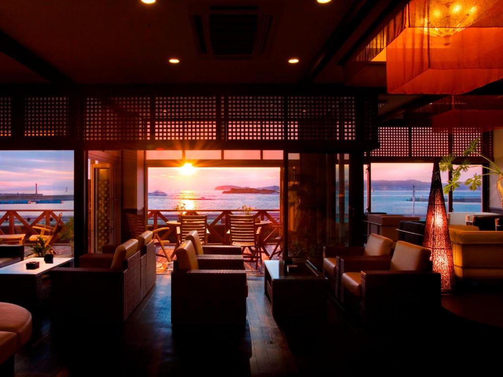un restaurante con sofás y vistas al océano en Himakajima Isuzukan, en Minamichita