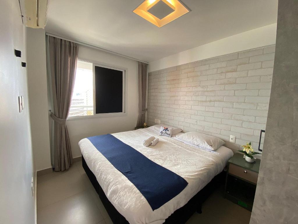 a bedroom with a large bed with a brick wall at Helbor My Way - Compactos de luxo in Fortaleza