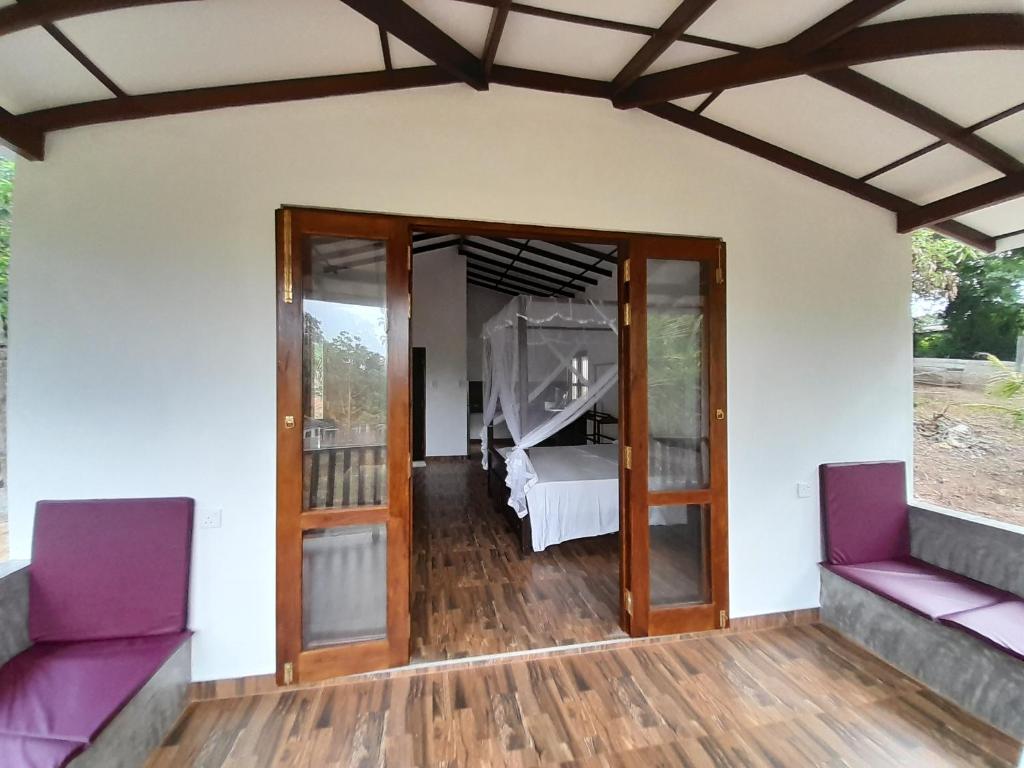 a room with sliding glass doors and a room with a piano at Villa Tanzanite in Tangalle