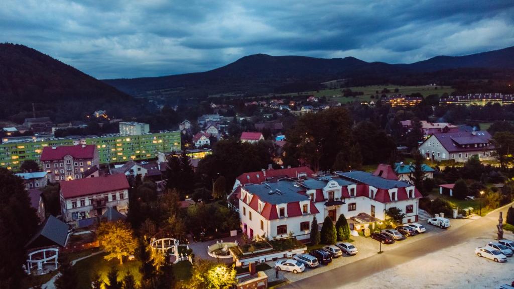 a town at night with cars parked in a parking lot at Dworek Galosa in Stronie Śląskie