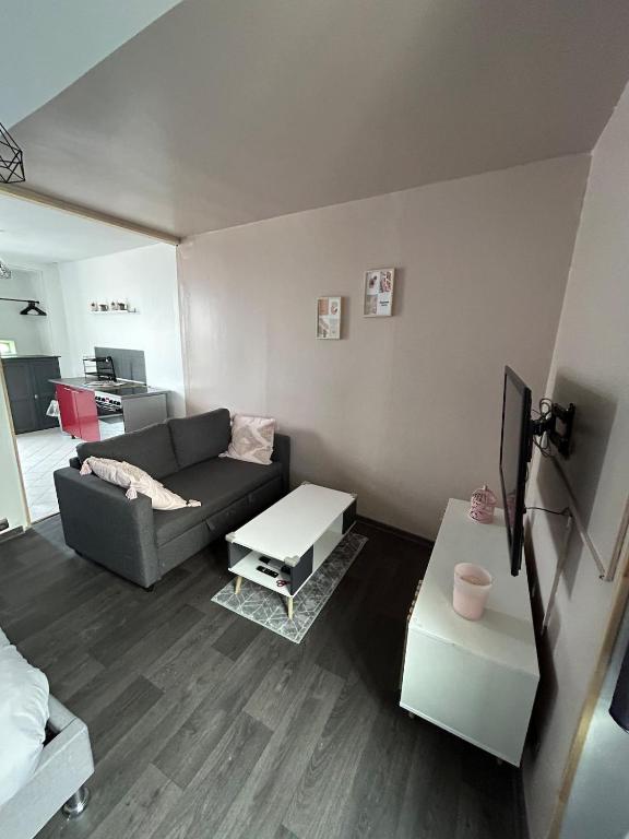 un salon avec un canapé et une table dans l'établissement Studio indépendant, à Saint-Éloi