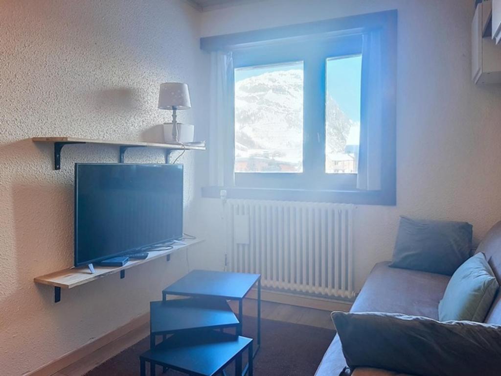 un salon avec un canapé et une télévision dans l'établissement Charmant 2 pièces à Val d'Isère, 4 pers, proche centre, TV, WiFi - FR-1-518-164, à Val dʼIsère