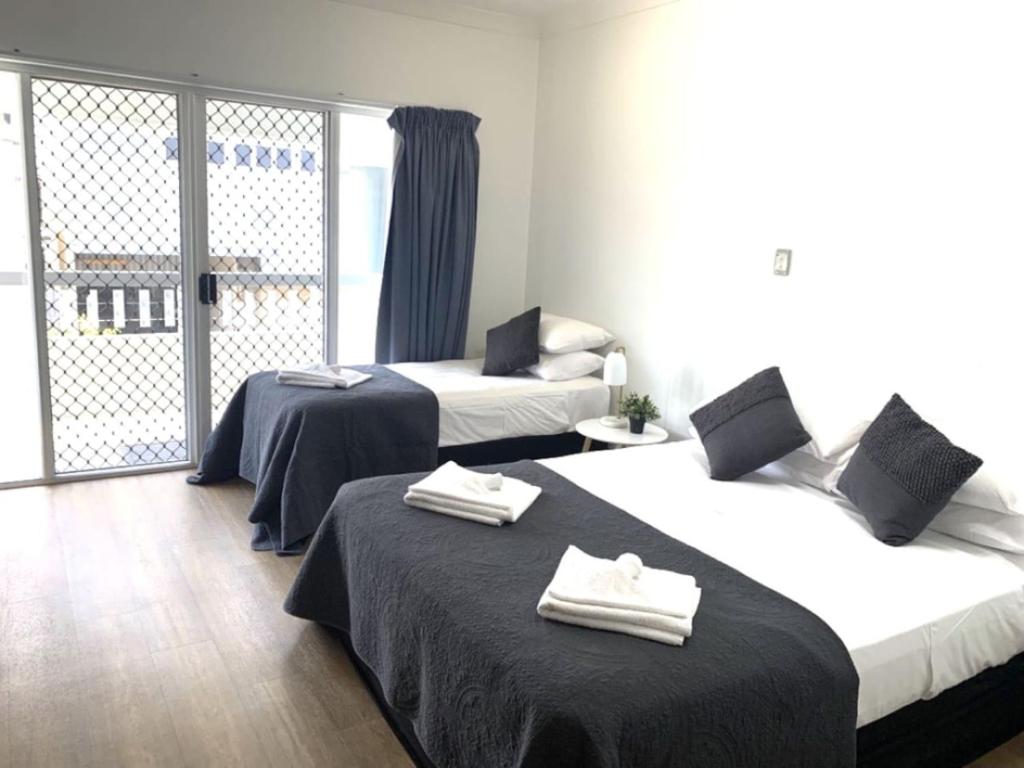 een hotelkamer met twee bedden en een balkon bij Accommodation at 134 Denham in Townsville