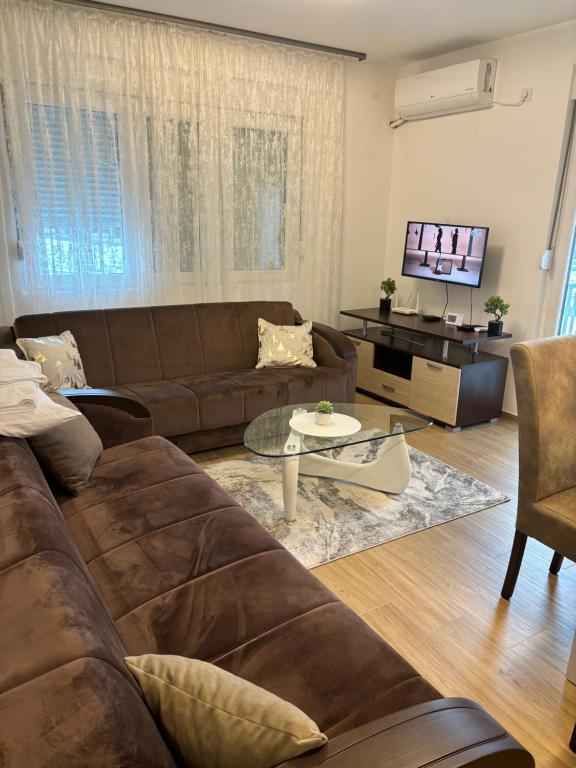 Una sala de estar con un sofá marrón y una mesa. en Popovic, en Ub