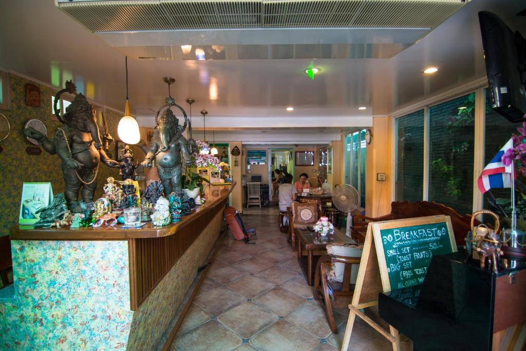 een restaurant met een bar met beeldjes erop bij Samsen Sam Place in Bangkok