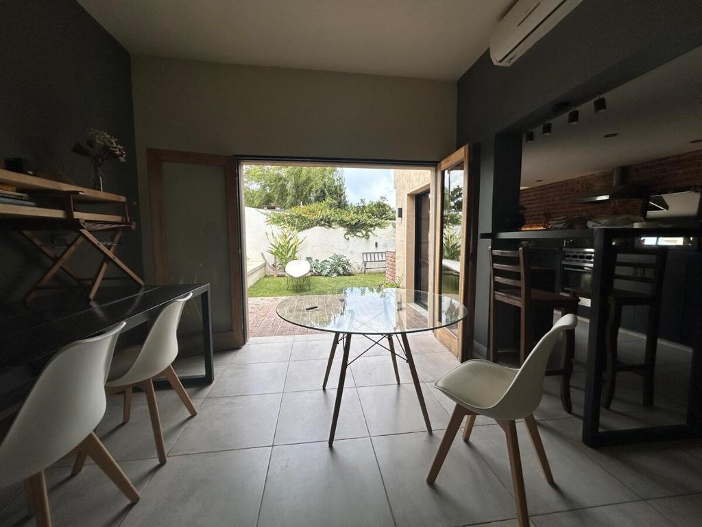 a dining room with a glass table and chairs at The amphitheater house in Villa María