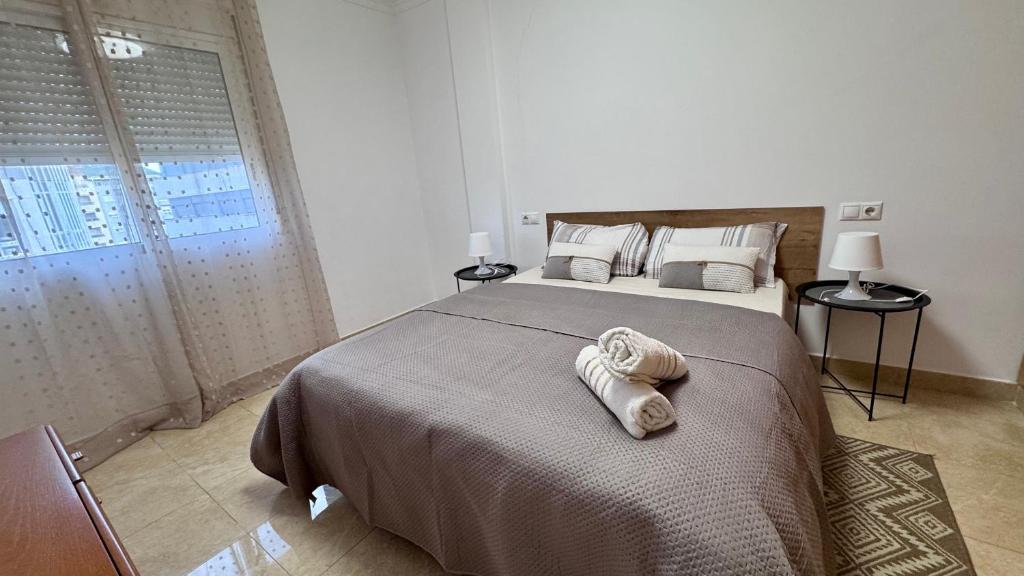 a bedroom with a large bed with towels on it at Amplio apartamento en centro in Denia