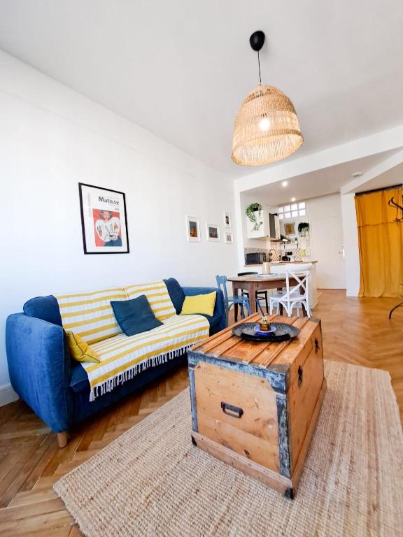 un salon avec un canapé bleu et une table dans l'établissement Le Charme - APPARTEMENT CENTRE VILLE, PROCHE DE LA PLAGE ET DU MARCHÉ, à Royan
