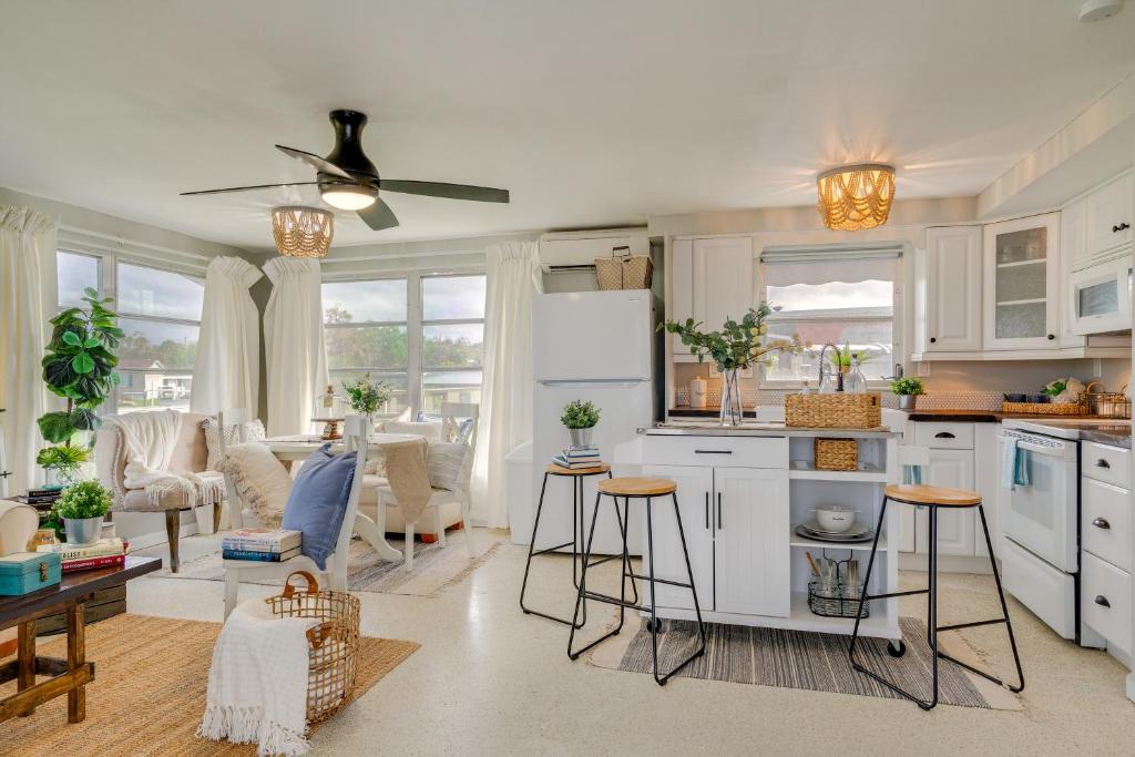 プンタ・ゴーダにあるDock and Lanai Waterfront Punta Gorda Cottageの白いキャビネット付きのキッチン、リビングルーム