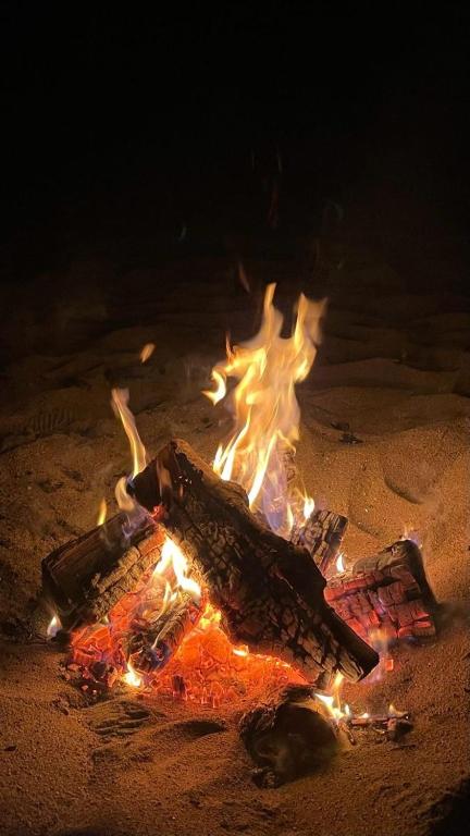 un fuoco nella sabbia sulla spiaggia di notte di Waha a Ismant