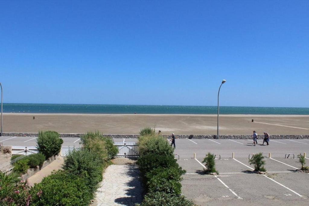 - un parking avec une plage en arrière-plan dans l'établissement Appartement 2 pièces PORT LA NOUVELLE PN390-013, à Port-la-Nouvelle