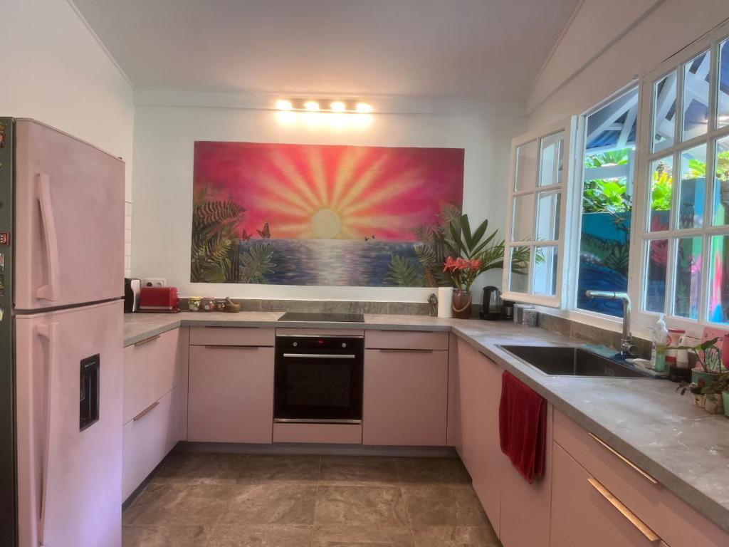 a kitchen with a large painting on the wall at Wonderland Villa in Petit-Bourg