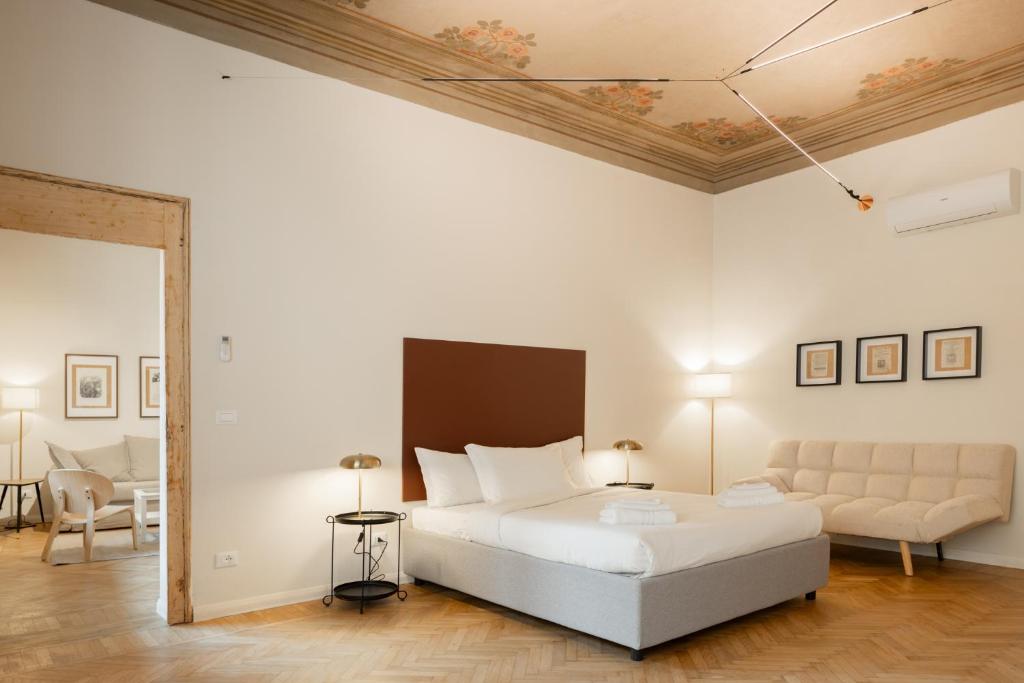 ボローニャにあるAzeglio Luxury roomのベッドとソファのある白い寝室