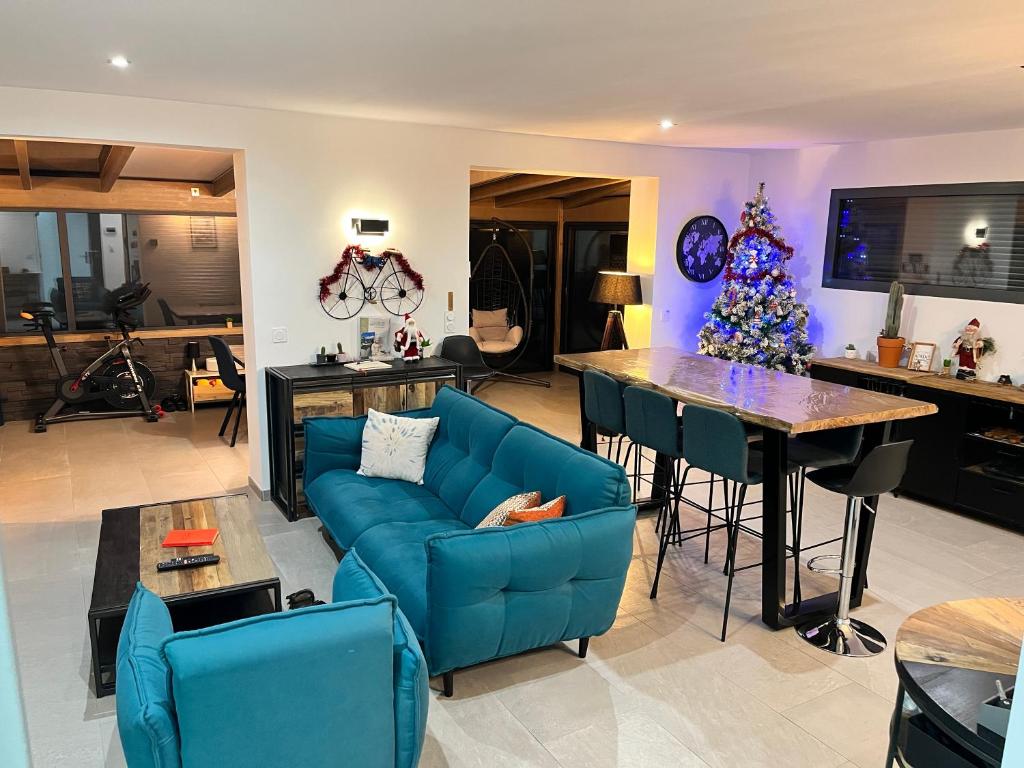 un salon avec un canapé bleu et une table dans l'établissement Maison Cosy à la montagne, à Châtillon-de-Michaille