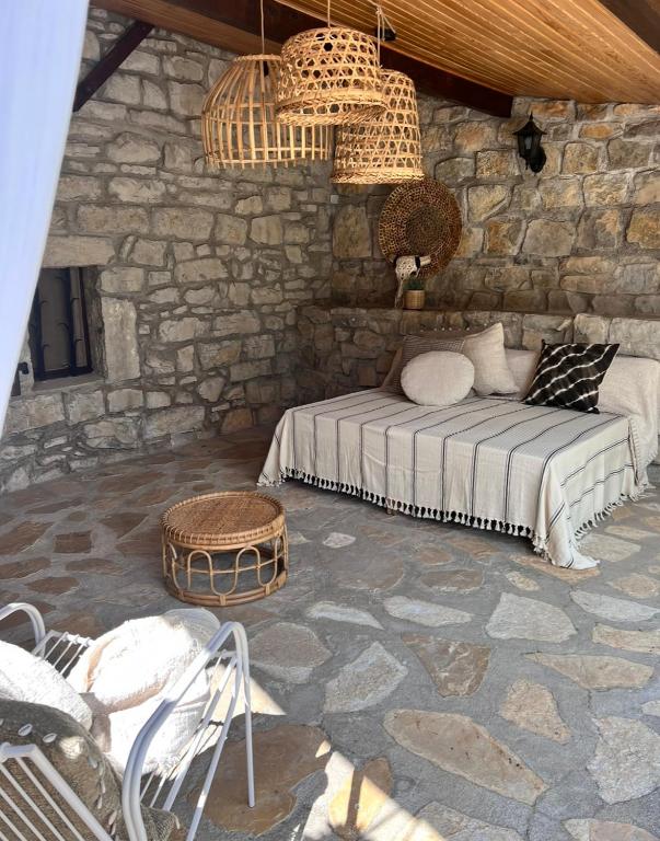 une chambre avec un lit et un mur en pierre dans l'établissement Petit mas familial Ardéchois, aux Vans