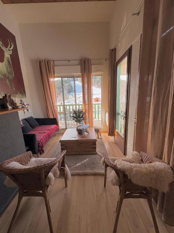 un salon avec un canapé et une table dans l'établissement Ax 3 Domaines Plateau de Bonascre Charmant duplex face aux pistes avec terrasse, à Ax-les-Thermes