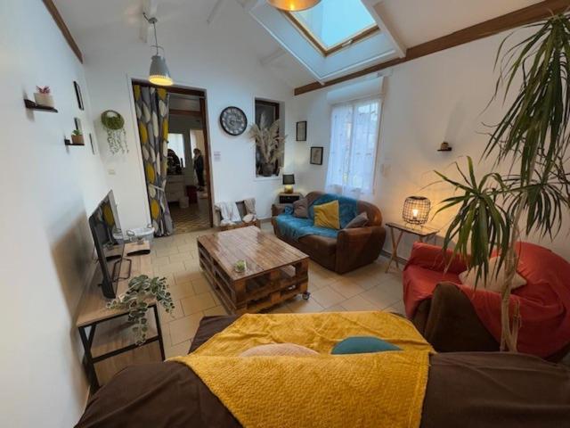 un salon avec un canapé et une table dans l'établissement Cozy house, center of Cotentin, à Saint-Sauveur-le-Vicomte