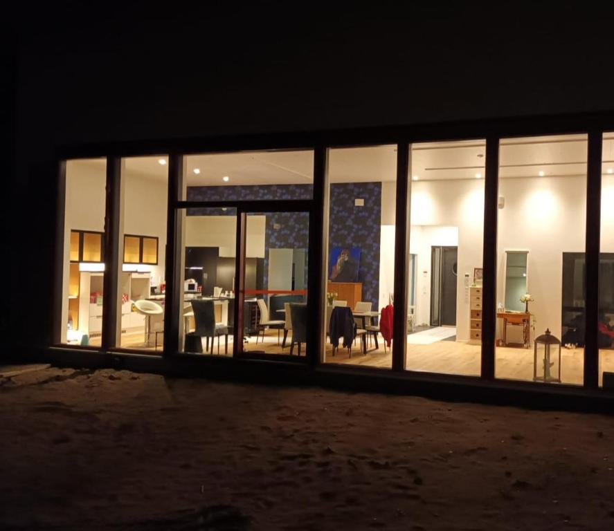 Un gran edificio de cristal con sala de estar y comedor. en Lapland Villa Ulpukka, en Rovaniemi