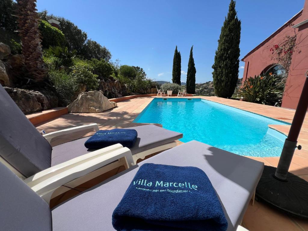 - une piscine avec 2 chaises longues devant un kiosque dans l'établissement Villa Marcelle, à Sainte-Maxime
