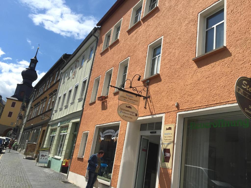 Ein Mann steht vor einem Gebäude auf einer Straße in der Unterkunft Ferienwohnung Harmonie - Zentral in Saalfeld