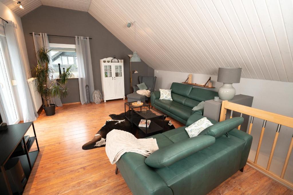 a living room with a green couch and a dog laying on the floor at Ferienhaus Glücklich am Harz in Goslar
