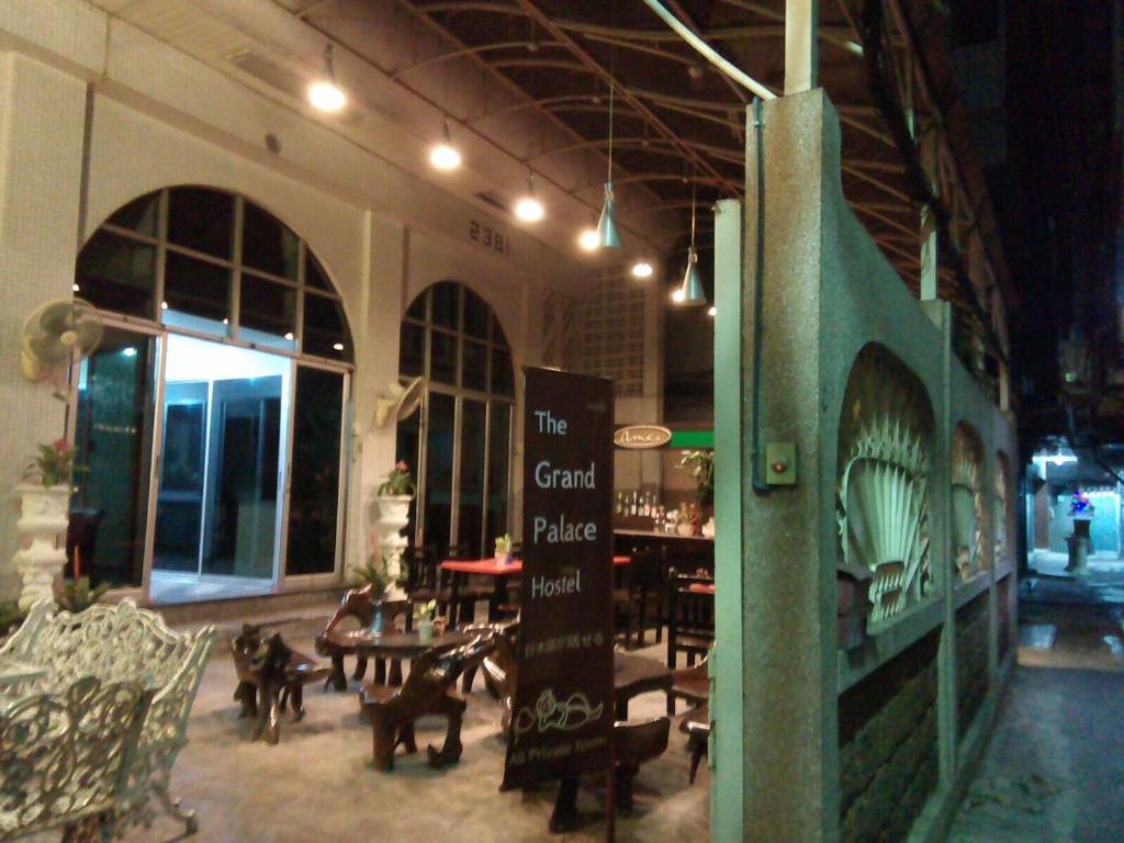 a restaurant with tables and chairs in a building at The Grand Palace Hostel in Bangkok