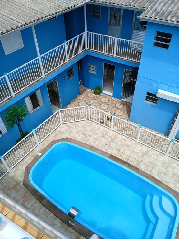 a swimming pool in front of a blue building at Pousada Cantinho Azul Qt 01 in Passo de Torres