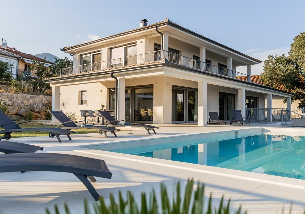 a house with a swimming pool in front of a house at Villa Maritima Opatija-Meerblick-Infinity Pool-Luxus-Relax in Opatija
