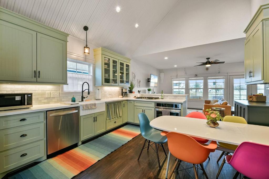 une cuisine avec des armoires vertes et une table et des chaises dans l'établissement Sun and Lake, à Dickinson