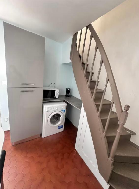 une cuisine avec un escalier et un lave-linge. dans l'établissement Bugle, à Saumur