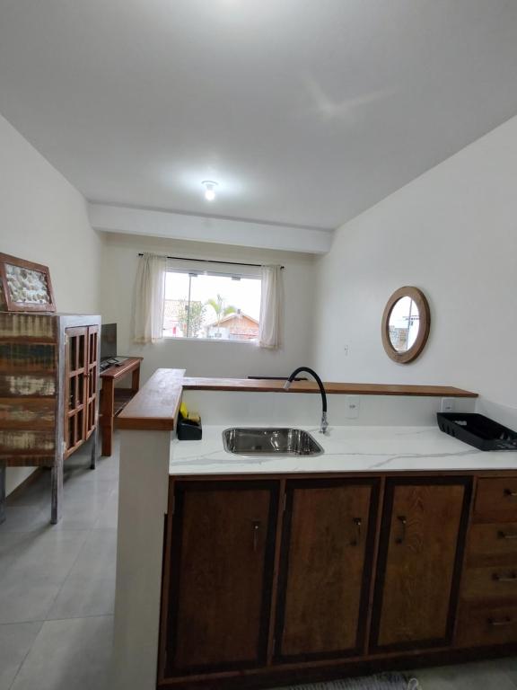 a kitchen with a sink and a window at Casas no Centro Histórico de Garopaba in Garopaba
