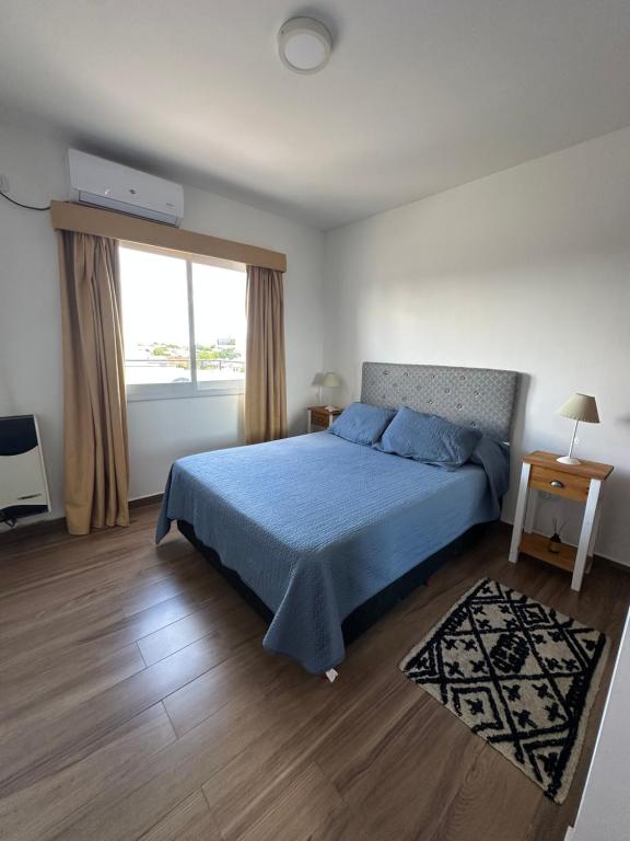 a bedroom with a blue bed and a window at Dpto 15 - Colon - 2 DORMITORIOS - PQ ALQUILERES TEMPORARIOS in Colón