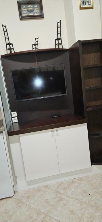 Elle comprend une télévision à écran plat installée au-dessus d'une table de télévision. dans l'établissement studio Chêne, à Bezons