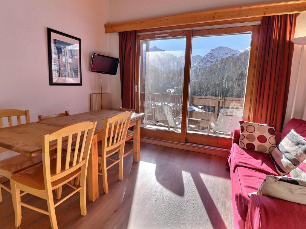 une salle à manger avec une table et une grande fenêtre dans l'établissement Charmant Duplex sur Pistes, Orienté Sud, 2 Chambres, Mezzanine, Équipé, Calme - FR-1-182-212, à Les Allues