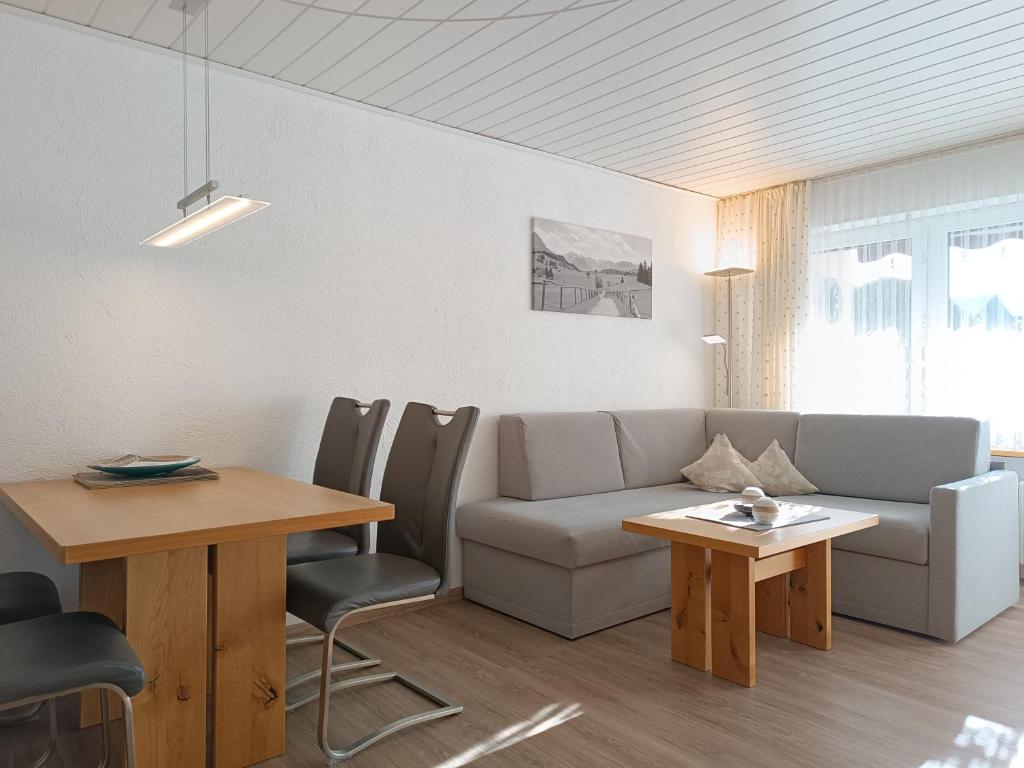 a living room with a couch and a table at 2-Raum FeWo Edelweiß - Hallenbad & Sauna in Fischen