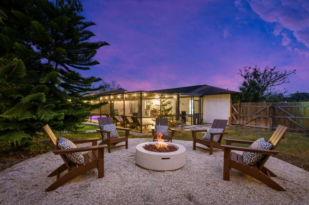 a backyard with a fire pit and chairs and a house at Poolside Fun Games Perfect Family Escape in Largo